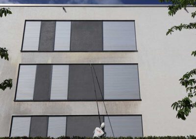 Auftragen des Reinigungsmittels zum Lösen des Fassadenschmutzes mit Teleskoplanze von Firma algenfiX