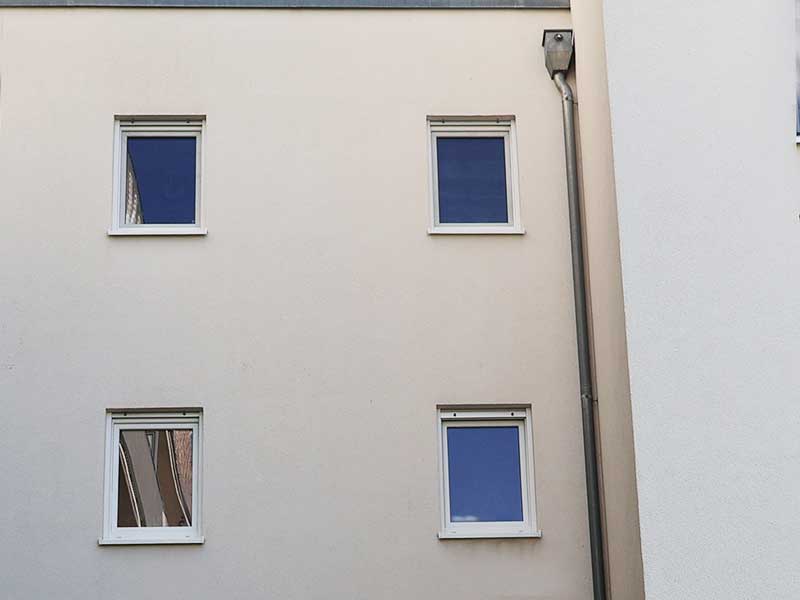 Mehrfamilienhausfassade nach algenfiX-Fassadenreinigung