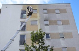 Reinigungsmittel Auftragung auf WEG Fassade mit mobiler Hebebühne in München von algenfiX
